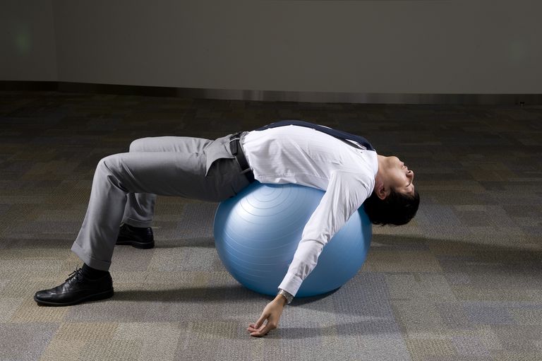 Estiramiento de la pelota de ejercicios para mantener el equilibrio y la estabilidad